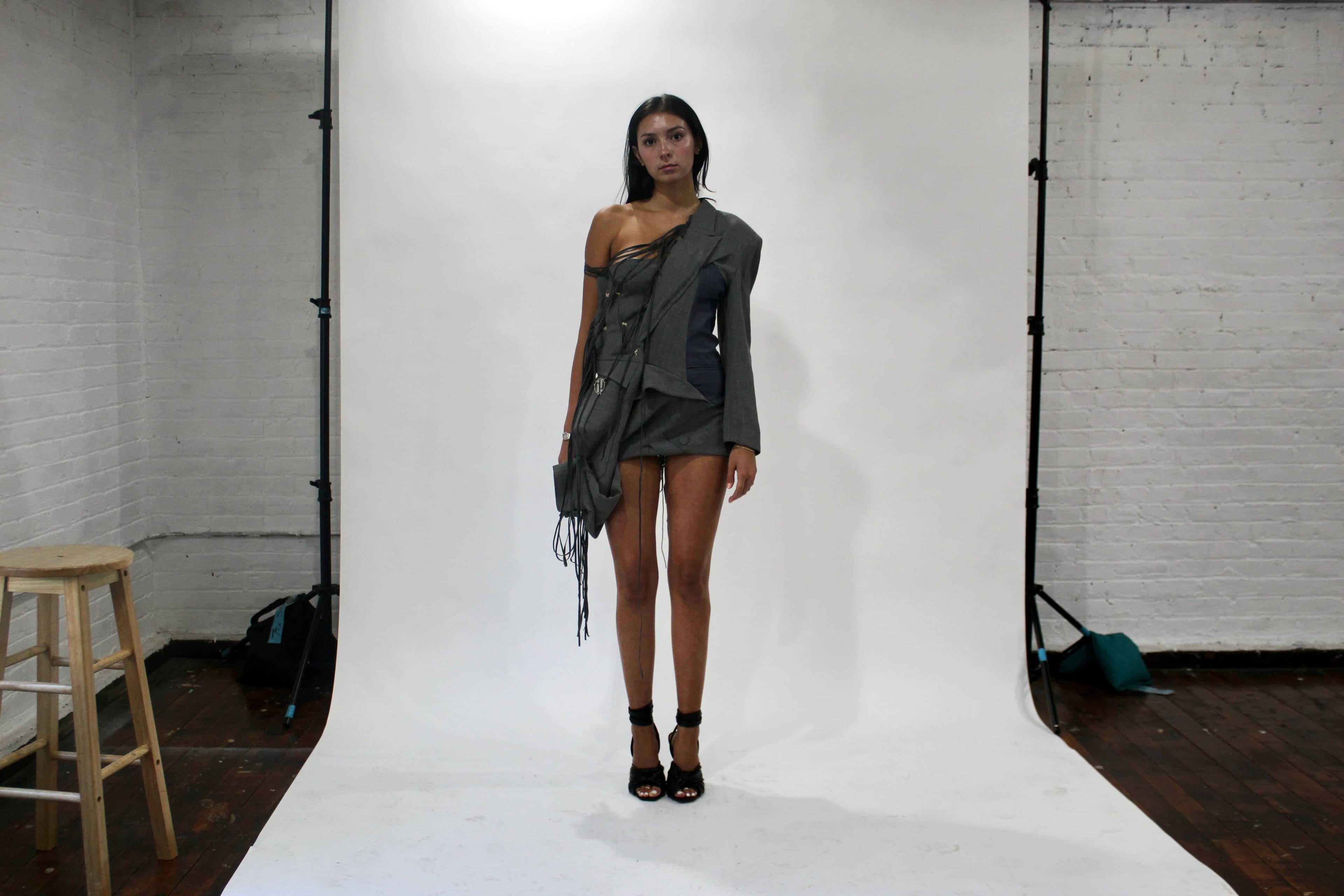 Behind-the-scenes fitting of a model wearing a Corii Burns MHII Collection piece in the New York City sewing studio, preparing for the NYFW runway show.
