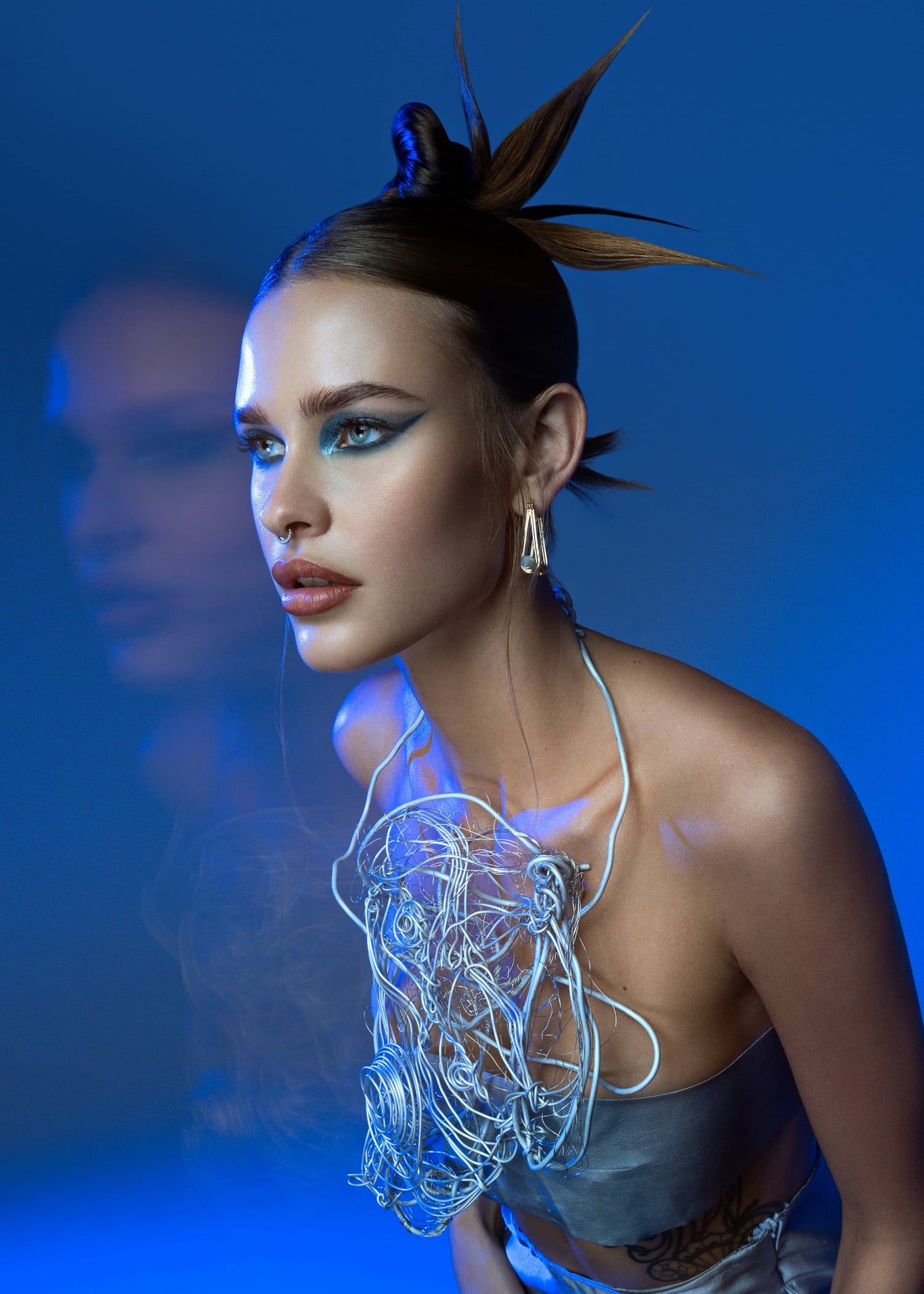 Close-up of model wearing Corii Burns silver skirt and sculptural top from the Santé Mentale Collection in Nikon USA TV commercial , luxury sustainable fashion, avant-garde editorial detail