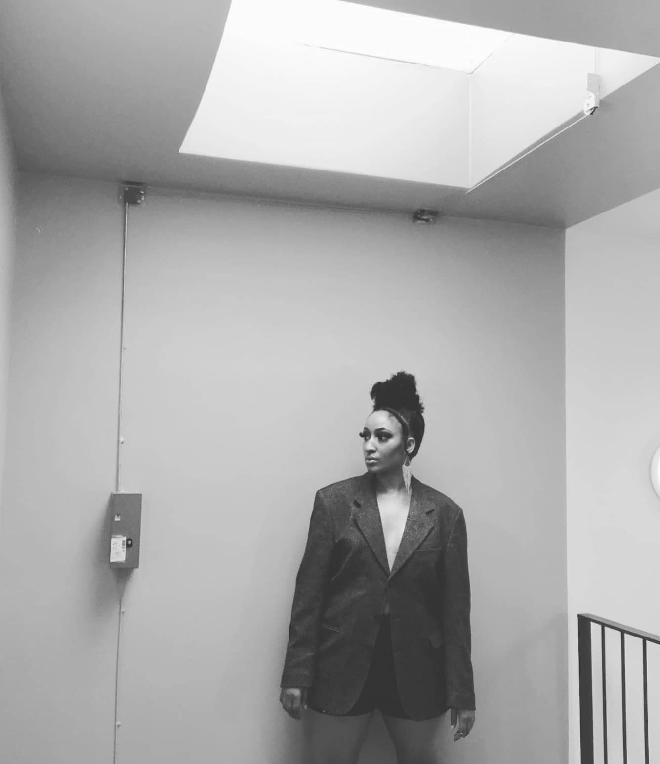 Designer Quieesha Burns standing inside the Corii Burns fashion house in Paris, captured in black and white, embodying the brand’s bold, visionary aesthetic