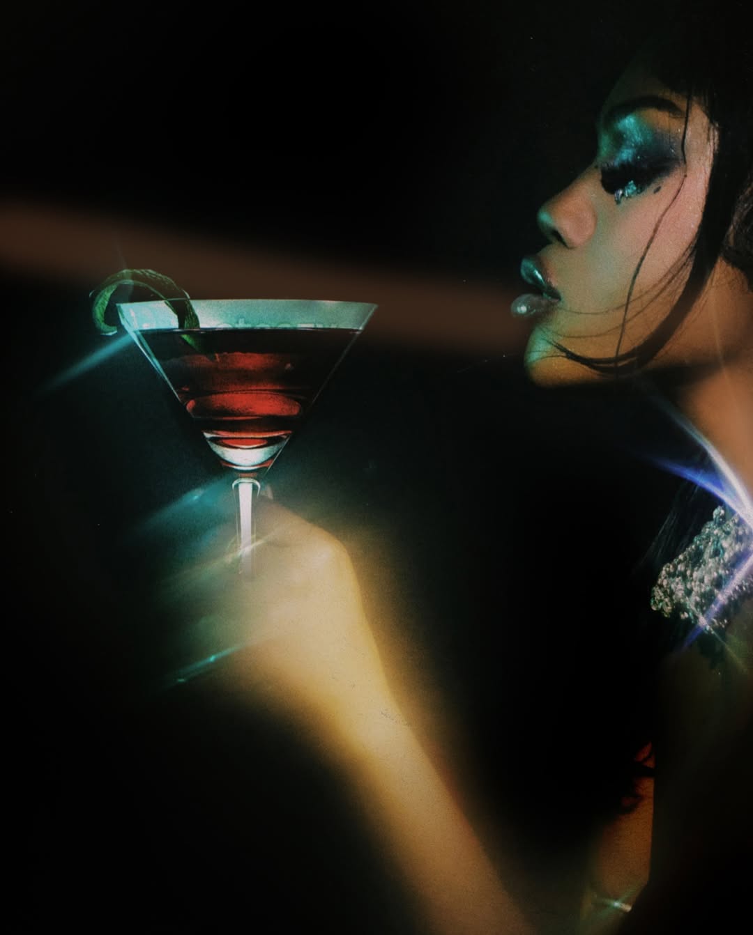 Woman holding a cocktail glass with a dark background