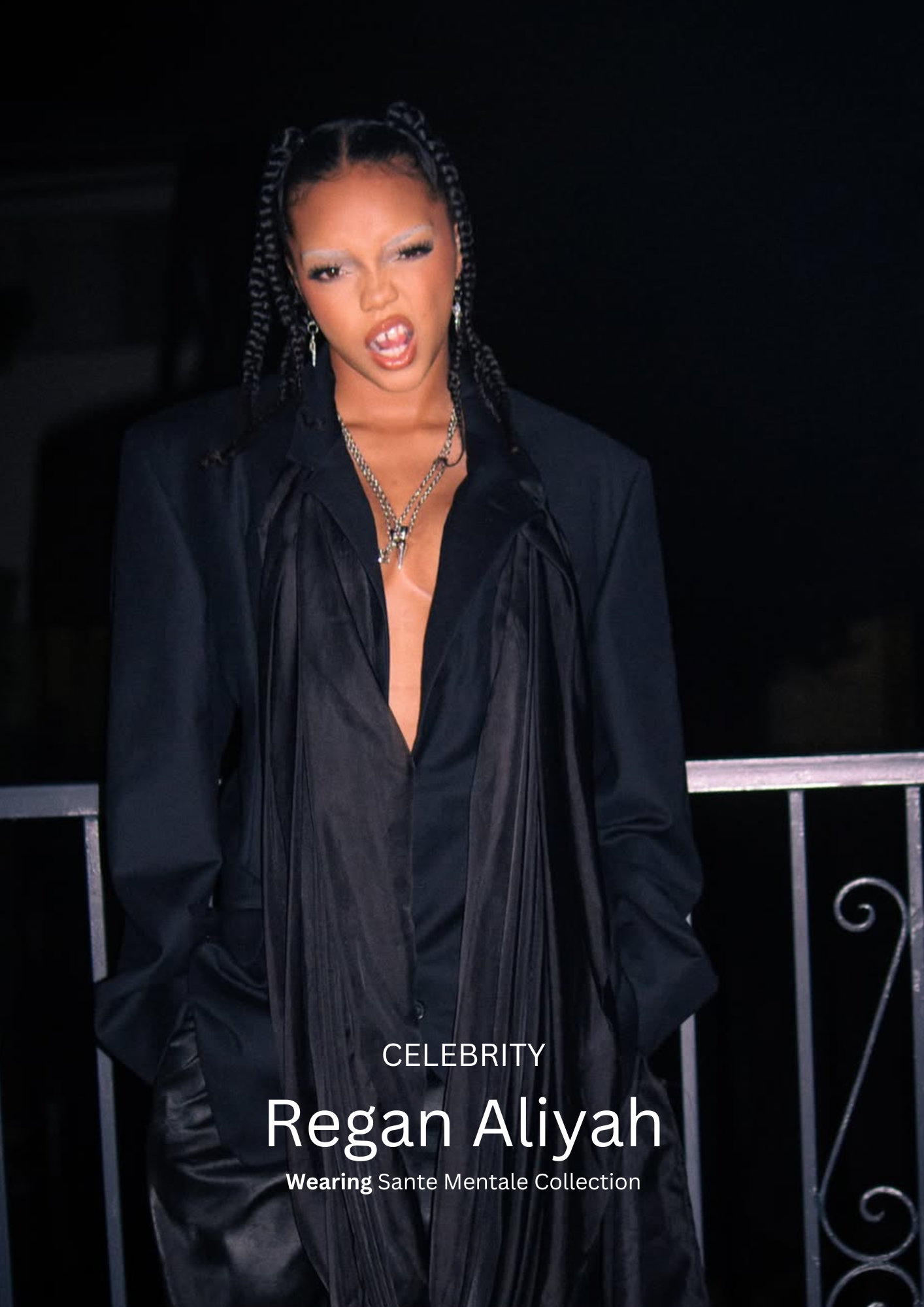 Regan Aliyah wearing Sante Mentale Collection's black outfit with a deep neckline, standing against a dark background. 